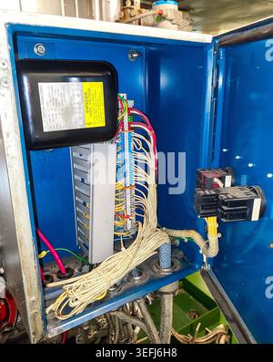 View of an electronic ignition transformer component surrounded by multi-colored control wiring inside a boiler electric panel. Stock Photo
