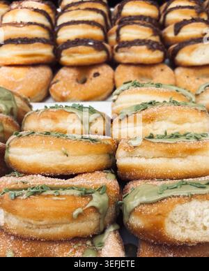 Tray of artisanal fried Italian donuts filled with sweet pistachio cream and coated in sugar. Delicious bakery desserts close up. Stock Photo