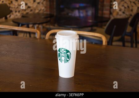 Starbucks coffee cup on a wooden table in a cozy cafe setting. London, UK, 3 July 2024 Stock Photo