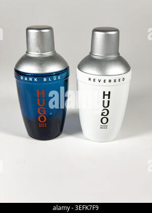 Two bottles of Hugo Boss fragrance including Dark Blue and Reversed editions displayed side by side on a plain light grey studio background Stock Photo
