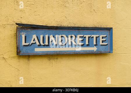Old directional 'Laundrette' sign on a wall. Stock Photo
