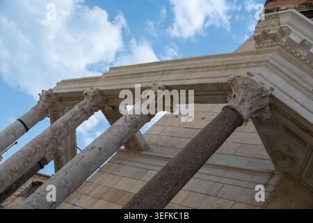 Low-angle close-up of Corinthian capitals and stone columns in Diocletian's Palace, Split, Dalmatia, Croatia with clouds and blue sky. Stock Photo