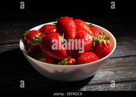 strawberry bowl on black wood background Stock Photo