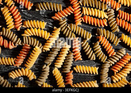 tri color pasta on black wood background top view Stock Photo