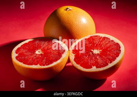 sliced grapefruit on red background Stock Photo