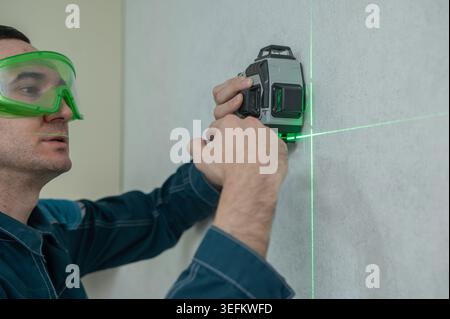 A man measures distance with a laser level.  Stock Photo