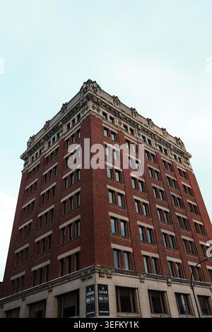 Low angle view of a ornate red brick heritage office building against a pale sky in downtown Montreal, Quebec, Canada. Stock Photo