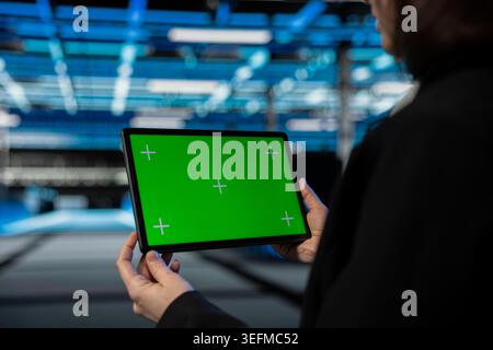 Green screen tablet used by data center technician to configure supercomputers hosting digital services. Closeup of server farm worker using chroma key touchscreen device to repair infrastructure rigs Stock Photo