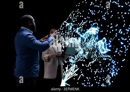 AI startup engineering team coworkers optimizing machine learning model, adjusting artificial neurons. Colleagues use device to look at neural network architecture visualization, modifying datasets Stock Photo