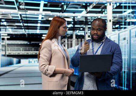 Data center engineering team deploying protection against network threats, working together. Server farm cybersecurity department IT staff members colleagues audit systems for computer bugs Stock Photo