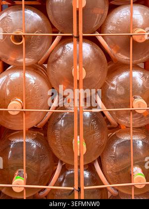 Large refillable water jugs stacked in a delivery rack in Mexico City, reflecting everyday reliance on bottled drinking water and private water distri Stock Photo