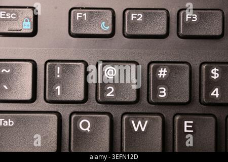 Black Computer Keyboard Macro Shot Highlighting 2 and At Symbol Key with Soft Blurred Backgrounds Top View Stock Photo