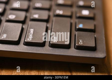 Side Angled Macro Close-Up Black Computer Keyboard Highlighting Shift Key on Blurred Tech Backgrounds Stock Photo