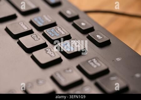 Side Angled Top View Macro Close-Up Black Computer Keyboard Highlighting Page Up Key on Blurred Tech Backgrounds Stock Photo