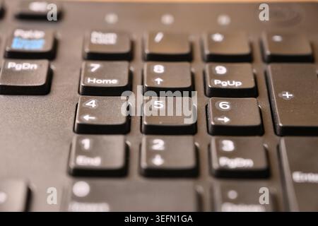 Angled Top View Macro Close-Up Black Computer Keyboard Highlighting Number 5 Key on Numeric Keypad with Blurred Tech Backgrounds Stock Photo