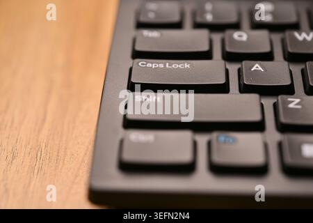 Black Computer Keyboard Macro Shot Highlighting Caps Lock Key with Soft Blurred Backgrounds Angled Top View Stock Photo