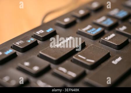 Macro Angled Top View Black Computer Keyboard Highlighting Backspace Key on Blurred Tech Backgrounds Stock Photo