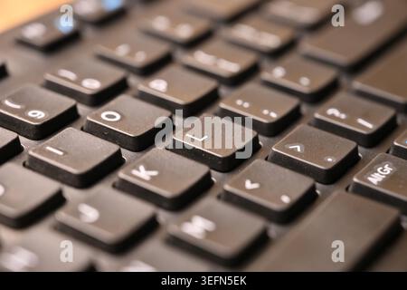 Macro Angled Top View of Black Computer Keyboard Highlighting “L” Key on Blurred Tech Backgrounds Stock Photo