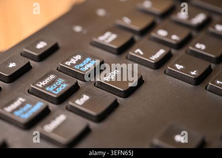 Black Computer Keyboard Macro Shot Highlighting Page Down Key with Soft Blurred Backgrounds Angled Top View Stock Photo
