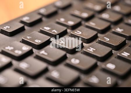 Macro Top View Black Computer Keyboard with Yellow “Y” Key on Blurred Backgrounds Close-Up Tech Concept Stock Photo
