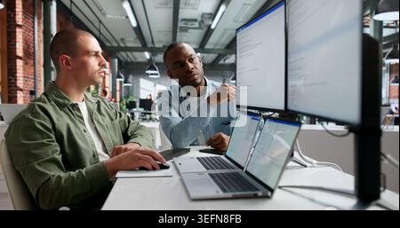 Two Young Software Engineers Working Together On Secure Web Coding. Stock Photo