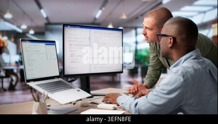 Two Software Engineers Collaborate On Secure Coding For Cloud Systems. Stock Photo