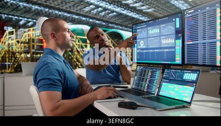 Young Aerospace Engineer Is Using SCADA Software To Check Airplane Engines. Stock Photo