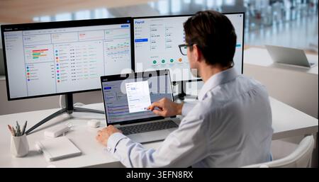 Mature Business Manager Reviews OKR Dashboard On Laptop Tracking Workforce Progress And Performance. Stock Photo