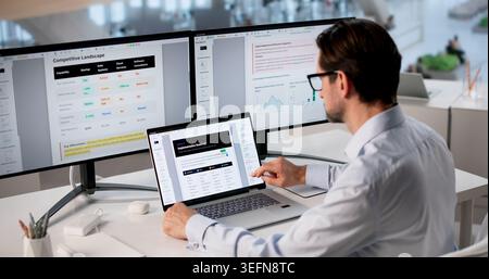 Man Reviews AI Strategy Documents On Laptop, Preparing Business Presentation. Stock Photo