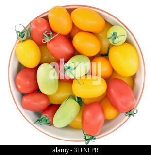 Colorful mini plum tomatoes in a ceramic bowl on white backgrounds. The colors are red, green, yellow, and orange. Stock Photo