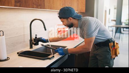 Repair, check or plumber in kitchen with tools, tap testing or sewer review in system maintenance. Inspection, servicing or handyman with water Stock Photo