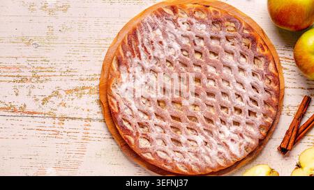 Homemade apple pie with cinnamon on a wooden background. Top view. Stock Photo