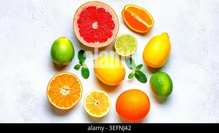 Fresh lemon, orange, grapefruit, lime, green leaves on light background, top view. Citrus Juice Concept, Vitamin C, Fruits. Stock Photo