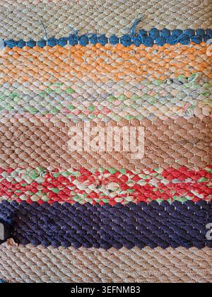 The top view shows a rag rug with striped designs made from various recycled fabric scraps. The rug lies flat against a surface, displaying its unique Stock Photo