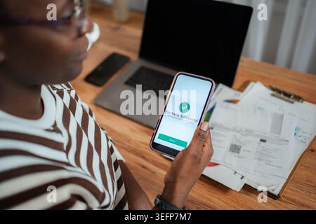 Person holding a smartphone displaying a successful online payment notification Stock Photo