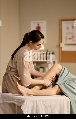 Adult Woman Therapist Massaging Patient Leg in Rehab Clinic Stock Photo
