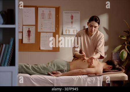 Adult Woman Therapist Giving Back Massage in Wellness Clinic Stock Photo