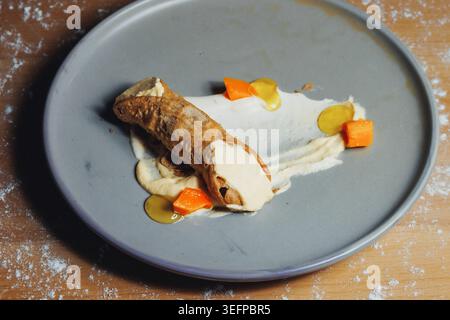 Delicate presentation of bread and vegetables on a gray plate Stock Photo
