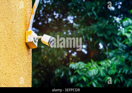A security camera installed on the exterior wall of a building, designed to monitor and enhance security in urban or residential environments for safe Stock Photo