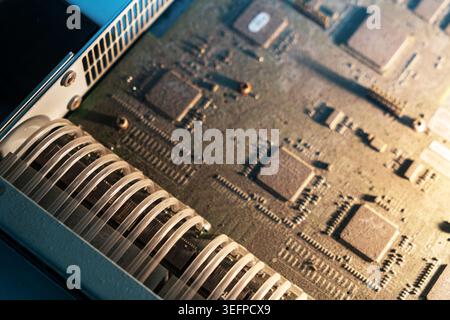 A detailed close-up view of a computer processor installed on a circuit board, showcasing intricate electronic components, pathways, and microchips. Stock Photo