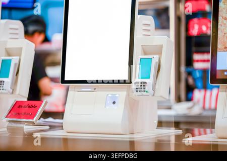 A modern retail store checkout area featuring an electronic payment system with a large touchscreen monitor and card reader, enhancing shopping effici Stock Photo