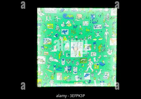 Illuminated square glass panel with abstract green cartoon illustrations and drawings on a dark black background Stock Photo