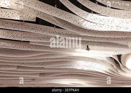 Modern abstract white wave ceiling panel design with perforated dots pattern texture close up Stock Photo