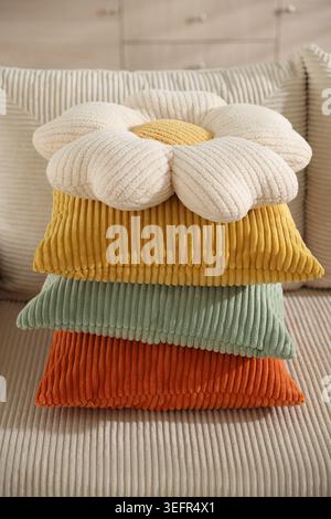 Stack of colorful pillows on soft sofa indoors, closeup Stock Photo