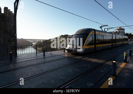 Porto, May 16 2026: Metro do porto tram traveling on the iconic dom luis i bridge over the douro river. Stock Photo