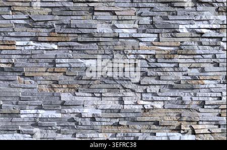 External wall coating made of bricks of natural gray, white and brown rocks. Full frame. Background and texture. Stock Photo