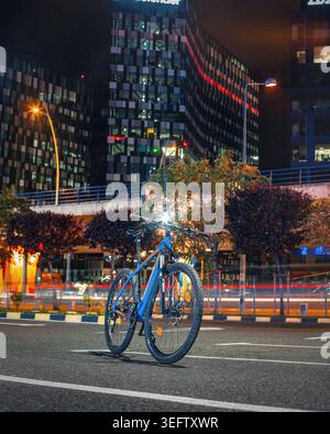Blue mountain bike standing on urban street at night Stock Photo