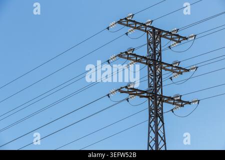 High Voltage Power Transmission Tower with Power Lines Against Blue Sky. Stock Photo