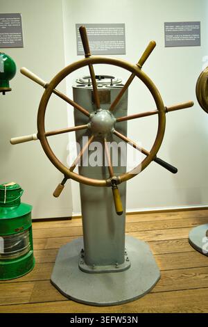 Vintage Ship Wheel Helm On Display In Maritime Museum With Nautical Steering Controls - Sea Fishing Museum in Świnoujście. Stock Photo