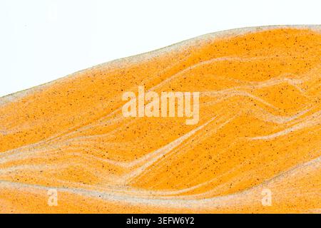 Close up bright orange liquid sand texture forming elegant flowing waves and wavy lines Stock Photo
